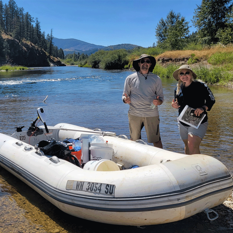 Two people next to a boat.