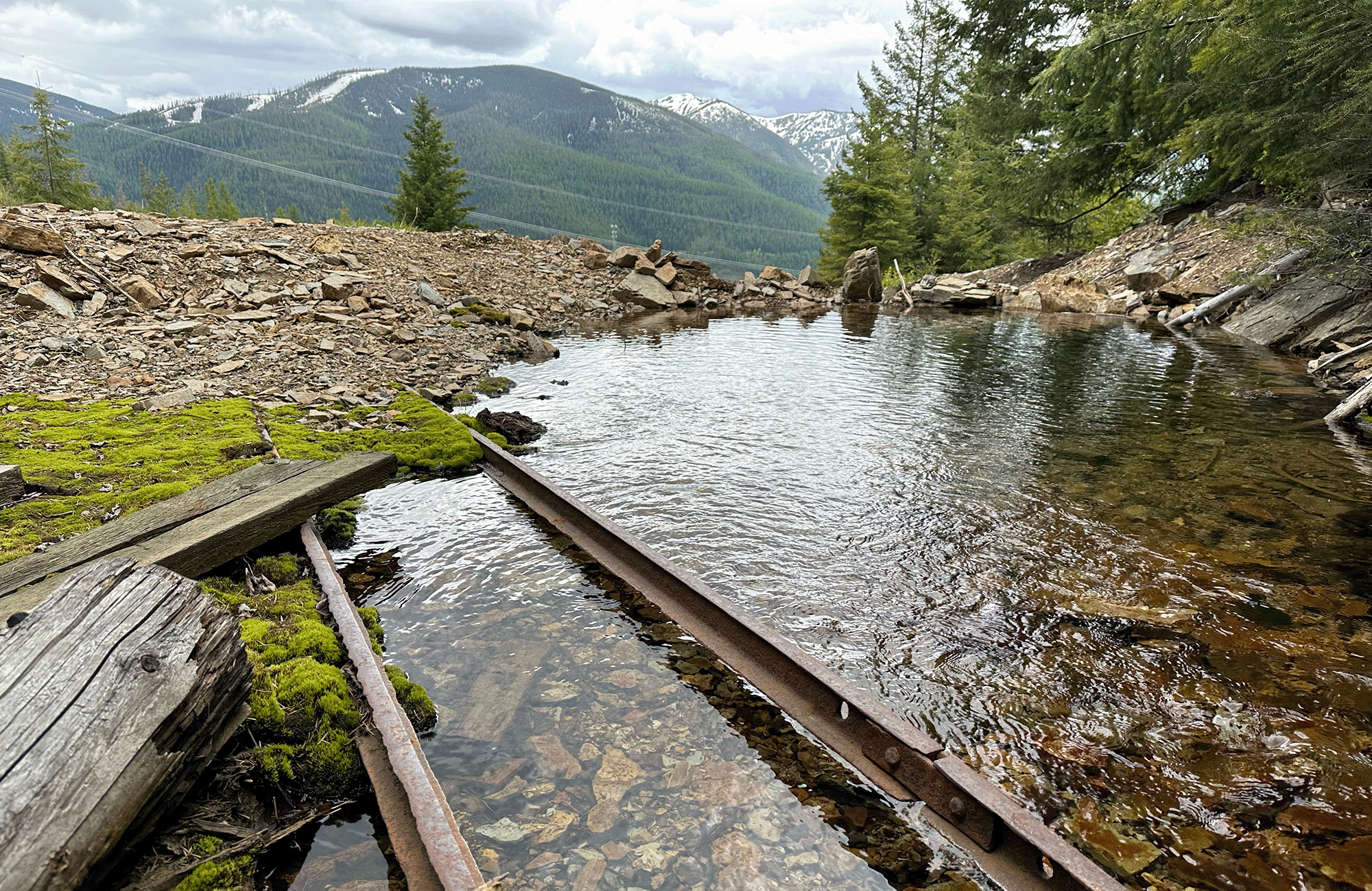 Old rail tracks run through a stream overlooking a valley in Idaho.