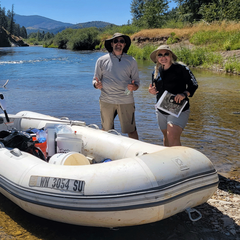 Two MFA team members standing besides a boat.