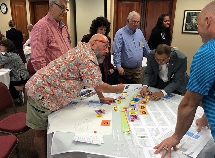 Members of the public standing around a table looking at plans.